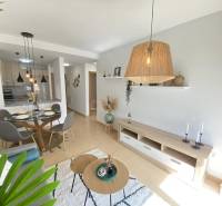 Interior of a 3-room apartment with a dining table, living room, and a vase on the floor.