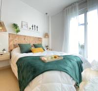 A bright bedroom in a 3-room apartment with a wooden headboard and green accessories.