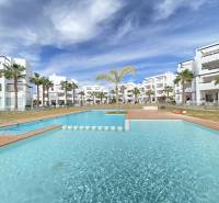 White residential buildings and a pool in the Las Terrasas de la Torre resort in Roldán.