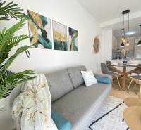 Living room with a sofa, decorations, and a dining area in a 3-room apartment.