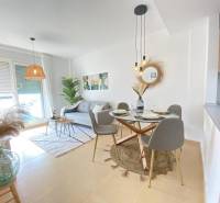 Bright living room of a three-room apartment with a dining area and a sofa.