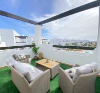 A terrace in a 3-room apartment with a view of the resort and comfortable seating.