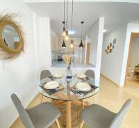 Dining area in a 3-room apartment with a round table and pendant lights.