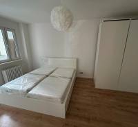 Bright bedroom with a built-in wardrobe and a double bed in a 2-room apartment.