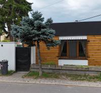 A family house on Poľná Street in Most pri Bratislave with wooden cladding and a garden.