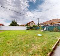 The garden of a family house in Most pri Bratislave on Poľná Street with a lawn and a deck chair.