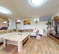 Living room in a family house with sofas, a coffee table, and a TV cabinet.