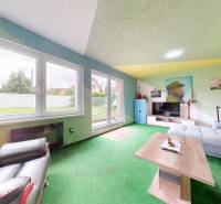 A comfortable living room with a sofa, coffee table, and television in a family house.