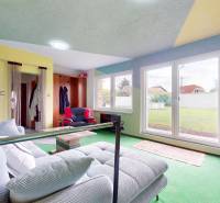 Living room in a family house with a sofa, coffee table, and a view of the garden.
