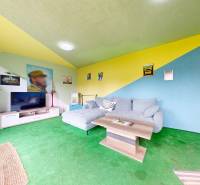 Colorful living room in a family house with a sofa, coffee table, and television.
