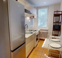 Kitchen in a studio apartment with a stove, microwave, and dining table.
