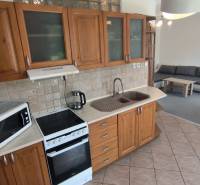 A kitchen unit with a dining table and a sofa in a 2-room apartment.