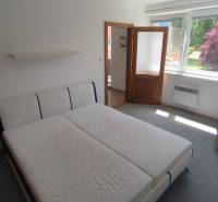 A bright room with a bed, a nightstand, and a window, suitable for a 2-room apartment.