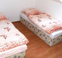 Children's room in a three-room apartment with two beds and simple wooden flooring.