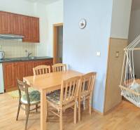 A kitchen with built-in cabinets, a dining table, and a rocking chair in a 3-room apartment.