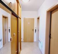 Hallway in a 3-room apartment with wooden built-in wardrobes and ceramic tiles.