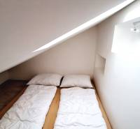An attic bedroom with a single bed and a skylight in a 3-room apartment.