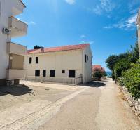 A view of the street with buildings in Novalja, near the sea, in front of a 2-room apartment.