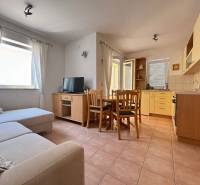 Living room in a 2-room apartment with a kitchenette, sofa, and dining table.