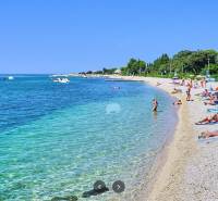 The beach in Novalja with tourists relaxing by the sea.