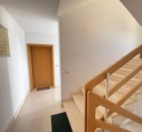 A hallway with a staircase and wooden railing in a 2-room apartment.