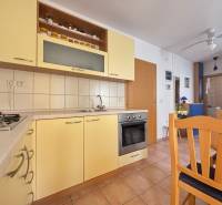 A kitchen in a 2-room apartment with wooden furniture and built-in appliances.