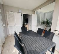Terrace in a 3-room apartment with a view, table, chairs, and potted plants.