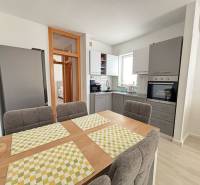 A kitchen in a 3-room apartment with a dining table and modern equipment.
