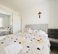 A bright bedroom with a mirrored wardrobe, a bed, and a chair in a 3-room apartment.