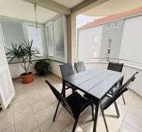 The balcony of a 3-room apartment in Novalja, with flowers and garden furniture on the tiles.