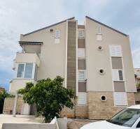 Exterior of a building in Novalja with a 3-room apartment, white shutters, and a balcony.