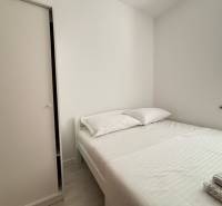 A bright bedroom with a comfortable bed and a white wardrobe in a 3-room apartment.