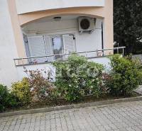 Facade of a 2-room apartment in Novalja with a balcony and greenery.