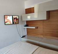 Interior of a 2-room apartment with a bedroom and TV, modern furniture on the wall.