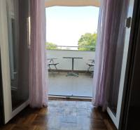 View from a 2-room apartment to a balcony with seating and a view of nature.