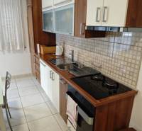 A kitchen in a 2-room apartment, equipped with appliances and storage spaces.
