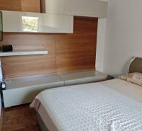 A bedroom in a 2-room apartment with wooden furniture and a comfortable bed.