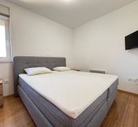 Bedroom with a double bed, television, and nightstands in a two-room apartment.