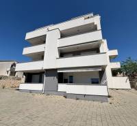 White building with terraces in Novalja, suitable for 2-bedroom apartments.