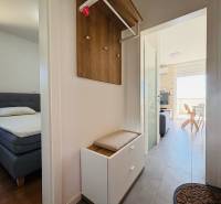 A corridor leading to the bedroom and living room in a 2-room apartment with light furniture.