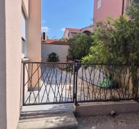 Enter through the gate with stones and a surfboard at the 2-bedroom apartment in Novalja.