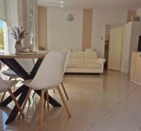 Interior of a 2-room apartment with a bright living room, dining table, and sofa.