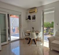 Interior of a 2-room apartment with a dining table, sofa, and access to the terrace.