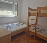 A bedroom in a two-room apartment with a bunk bed and one single bed.