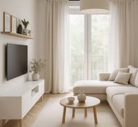 A bright living room in a two-room apartment with a sofa, a table, and a television on the wall.