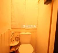 A bathroom in a 2-room apartment with tiles and storage space for toiletries.