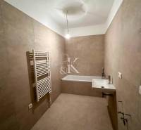 Bathroom in a 3-room apartment with a sink, bathtub, and tubular radiator.