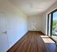 A room with a wooden floor and a large window in a 3-room apartment.