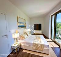 Elegant bedroom with large windows and a painting in a 3-room apartment, offering comfort and style.