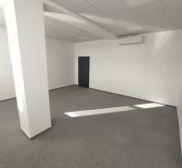 Office space with white walls, gray carpet, and an air conditioning unit.